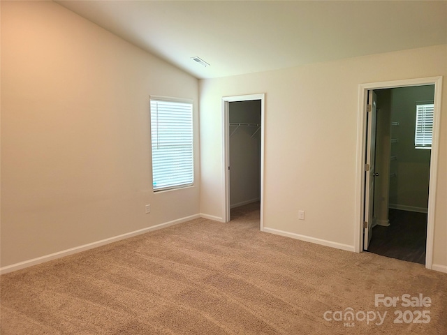 1195 Winding Creek Rd, Salisbury, NC 28146 - unfurnished bedroom featuring carpet, a walk in closet, baseboards, vaulted ceiling, and a closet
