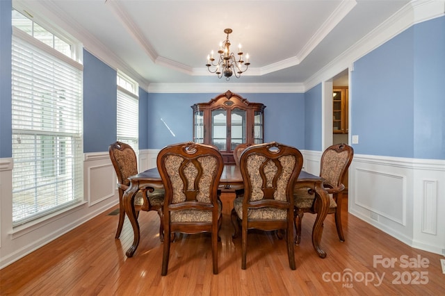 4201 Amber Leigh Way Dr, Charlotte, NC 28269 - dining room with a chandelier, a wainscoted wall, light wood-style floors, a decorative wall, and a raised ceiling