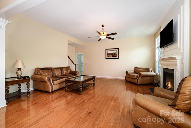 4201 Amber Leigh Way Dr, Charlotte, NC 28269 - living area featuring a glass covered fireplace, a ceiling fan, and light wood-type flooring