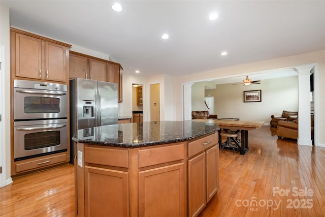 4201 Amber Leigh Way Dr, Charlotte, NC 28269 - kitchen with stainless steel appliances, ornate columns, light wood-type flooring, a center island, and recessed lighting