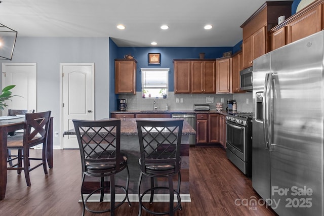 185 Willow Valley Dr, Mooresville, NC 28115 - kitchen with stainless steel appliances, a sink, a kitchen island, dark wood-style floors, and a kitchen bar