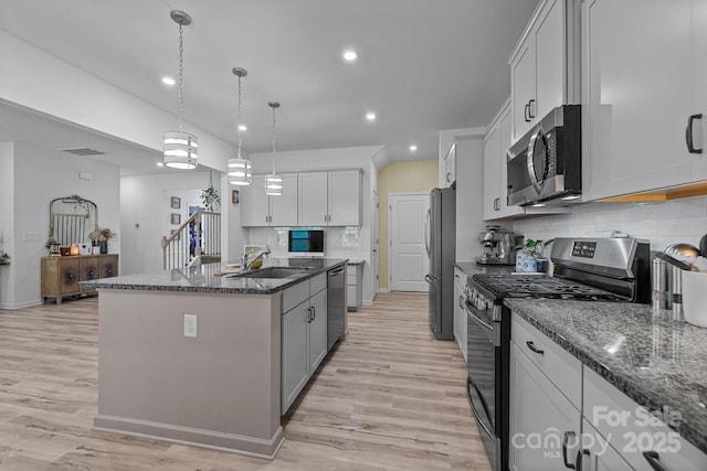 229 Cramerton Mills Parkway, Cramerton, NC 28032 - kitchen with appliances with stainless steel finishes, a sink, an island with sink, decorative backsplash, and dark stone countertops