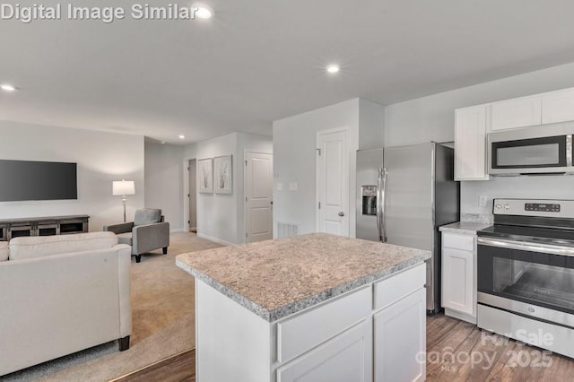 10127 Florentine Way, Charlotte, NC 28214 - kitchen with appliances with stainless steel finishes, open floor plan, light countertops, a kitchen island, and white cabinetry