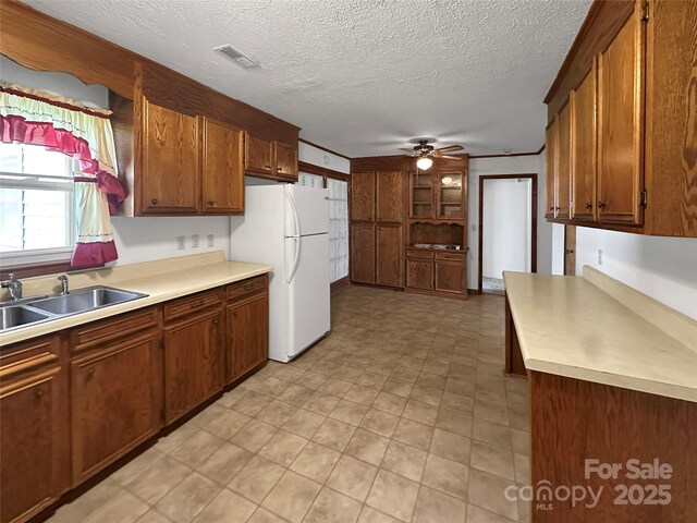 305 Rockdale Rd, Lawndale, NC 28090 - kitchen featuring ceiling fan, freestanding refrigerator, light countertops, a textured ceiling, and brown cabinets