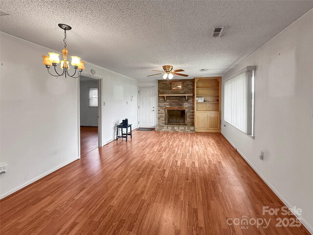 305 Rockdale Rd, Lawndale, NC 28090 - unfurnished living room featuring ceiling fan, light wood-type flooring, a fireplace, and a textured ceiling