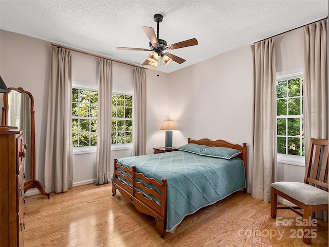 306 Croydon Dr, Hendersonville, NC 28791 - bedroom with light wood-style flooring, a textured ceiling, a ceiling fan, and baseboards