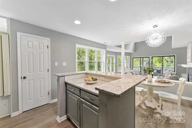 303 NW Dr, Davidson, NC 28036 - kitchen featuring open floor plan, light wood-style floors, recessed lighting, a kitchen island, and light stone counters