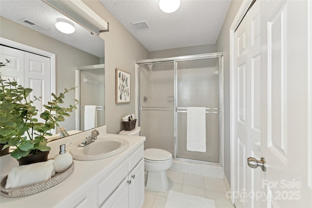 303 NW Dr, Davidson, NC 28036 - bathroom featuring a stall shower, vanity, toilet, a textured ceiling, and tile patterned floors