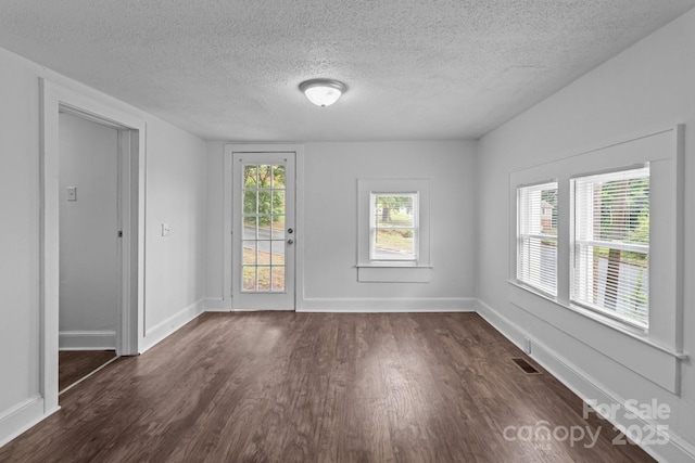 103 Garfield Ave, Albemarle, NC 28001 - unfurnished room featuring dark wood-style flooring, a textured ceiling, baseboards, and healthy amount of natural light