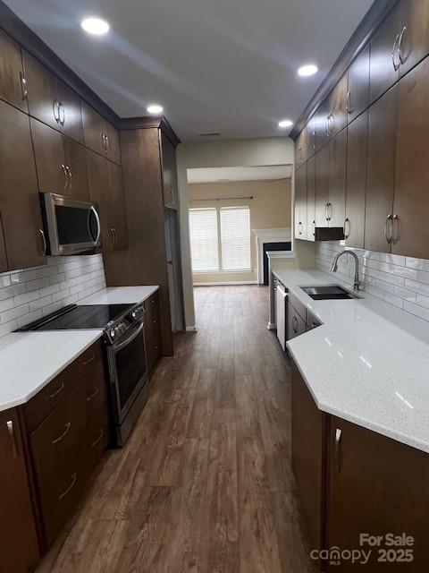 12378 Swan Wings Pl, Huntersville, NC 28078 - kitchen with stainless steel appliances, a sink, dark wood finished floors, backsplash, and recessed lighting