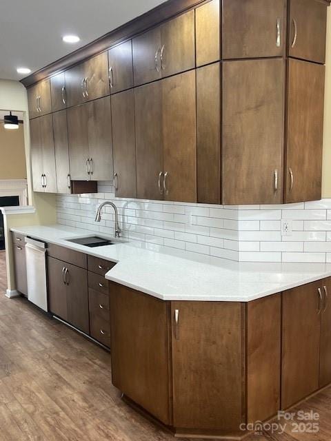 12378 Swan Wings Pl, Huntersville, NC 28078 - kitchen with a sink, stainless steel dishwasher, wood finished floors, backsplash, and light countertops