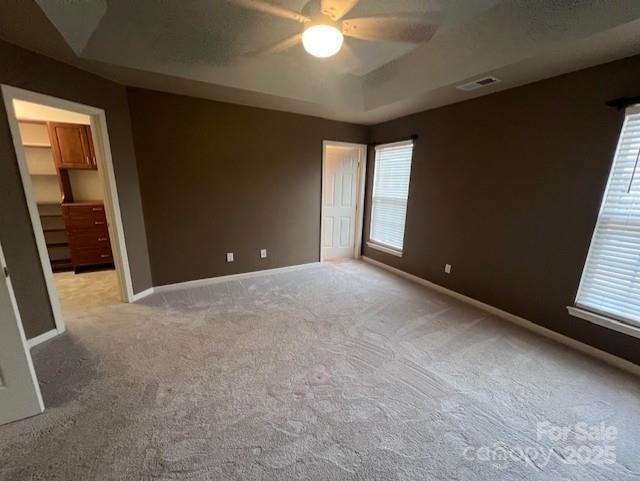 12378 Swan Wings Pl, Huntersville, NC 28078 - unfurnished room with light colored carpet, a ceiling fan, baseboards, and a tray ceiling