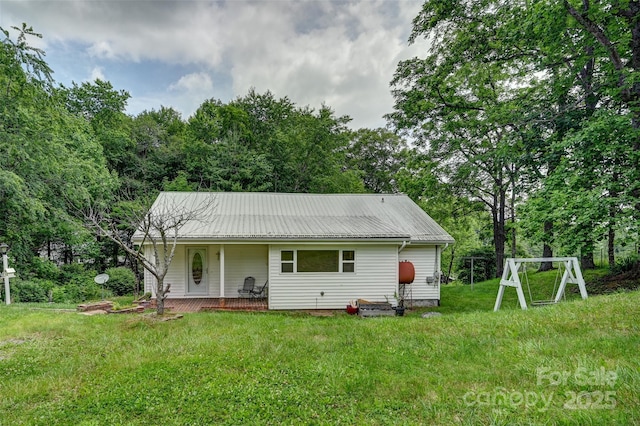 121 Walnut Holler Dr, Waynesville, NC 28786 - rear view of house featuring covered porch, metal roof, and a yard