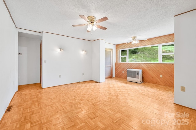 121 Walnut Holler Dr, Waynesville, NC 28786 - unfurnished room with a ceiling fan, wooden walls, a textured ceiling, heating unit, and baseboards