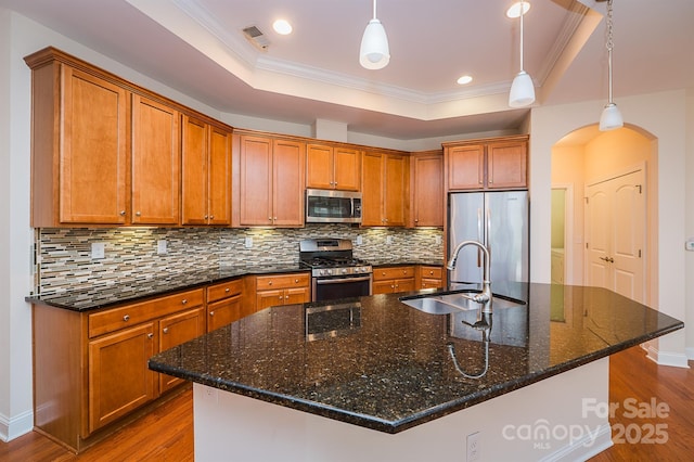 4518 Courtyard Blvd Unit 4, Harrisburg, NC 28075 - kitchen featuring stainless steel appliances, dark wood finished floors, arched walkways, a tray ceiling, and brown cabinetry