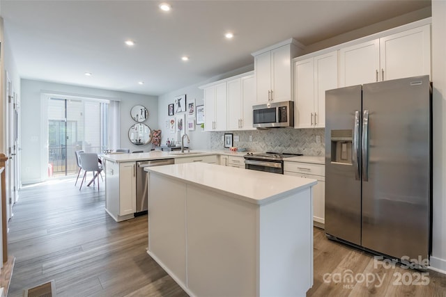 819 Anderson St, Charlotte, NC 28205 - kitchen with appliances with stainless steel finishes, a peninsula, light countertops, a sink, and a center island