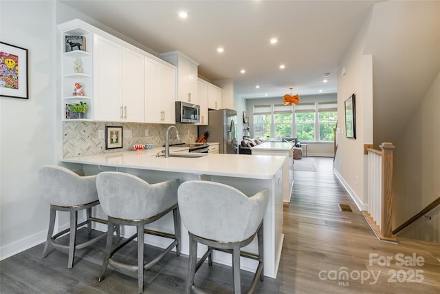 819 Anderson St, Charlotte, NC 28205 - kitchen featuring appliances with stainless steel finishes, a sink, open shelves, tasteful backsplash, and light countertops