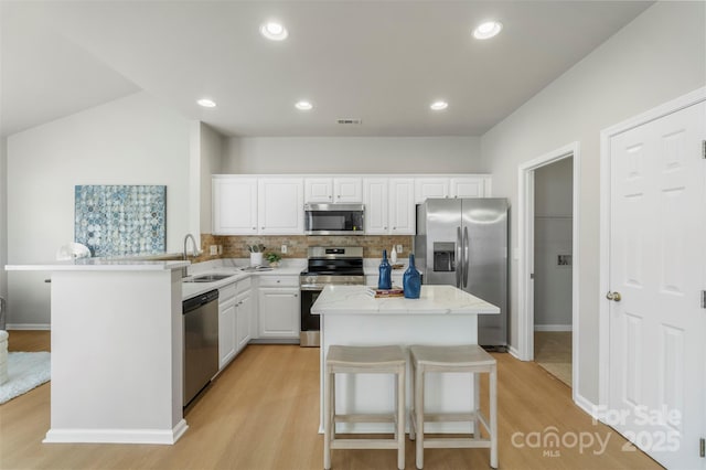 10225 Alexander Martin Ave, Charlotte, NC 28277 - kitchen with appliances with stainless steel finishes, light wood-style flooring, a peninsula, and white cabinets