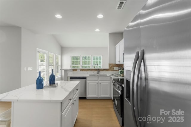 10225 Alexander Martin Ave, Charlotte, NC 28277 - kitchen featuring stainless steel appliances, a kitchen island, white cabinetry, recessed lighting, and tasteful backsplash