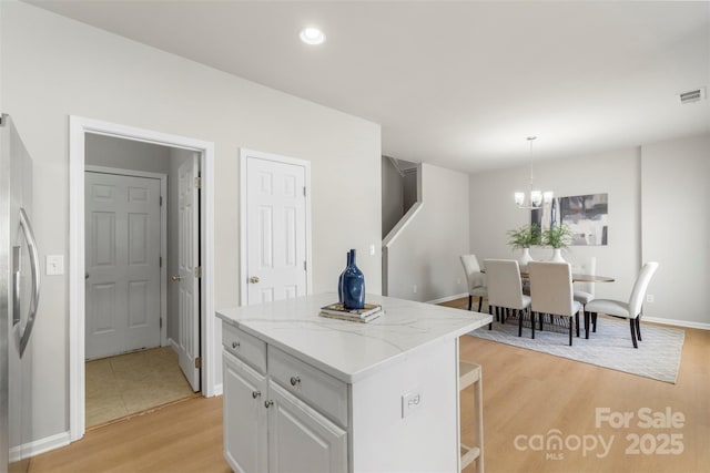 10225 Alexander Martin Ave, Charlotte, NC 28277 - kitchen featuring stainless steel fridge with ice dispenser, light wood-type flooring, a chandelier, a kitchen island, and pendant lighting