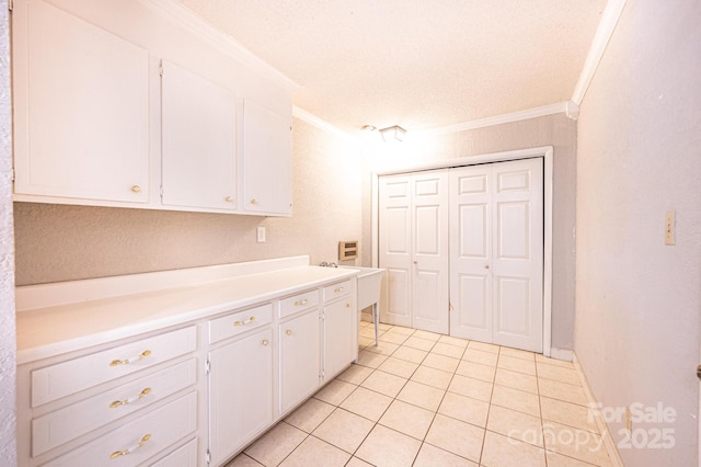 2031 36th St NE, Hickory, NC 28601 - kitchen with crown molding, light tile patterned floors, white cabinetry, light countertops, and a textured ceiling