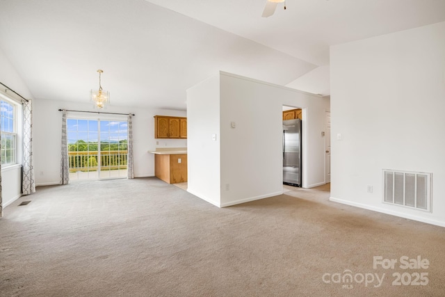 87 Collins Rd, Marshall, NC 28753 - unfurnished living room with vaulted ceiling, light colored carpet, a chandelier, baseboards, and a ceiling fan
