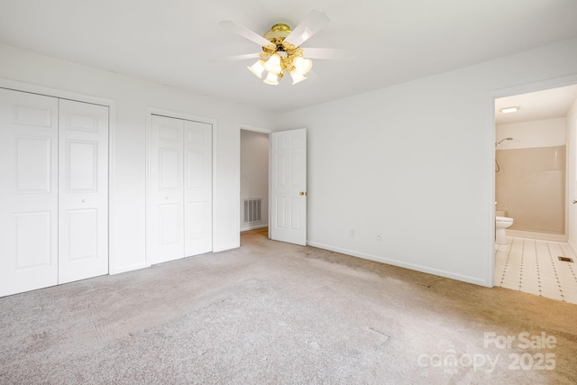87 Collins Rd, Marshall, NC 28753 - unfurnished bedroom with multiple closets, carpet flooring, ensuite bath, baseboards, and a ceiling fan