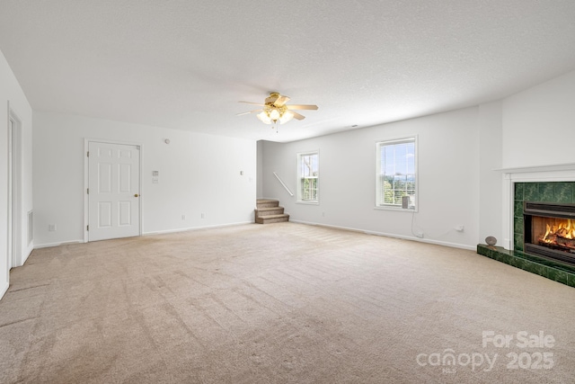 87 Collins Rd, Marshall, NC 28753 - unfurnished living room featuring stairs, a fireplace, carpet floors, a ceiling fan, and baseboards