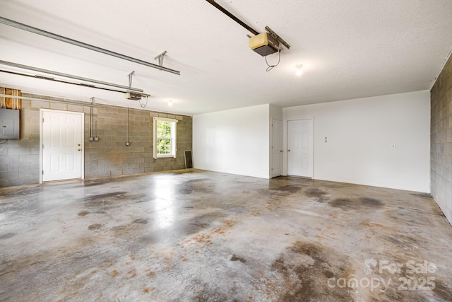 87 Collins Rd, Marshall, NC 28753 - garage with a garage door opener, electric panel, and concrete block wall