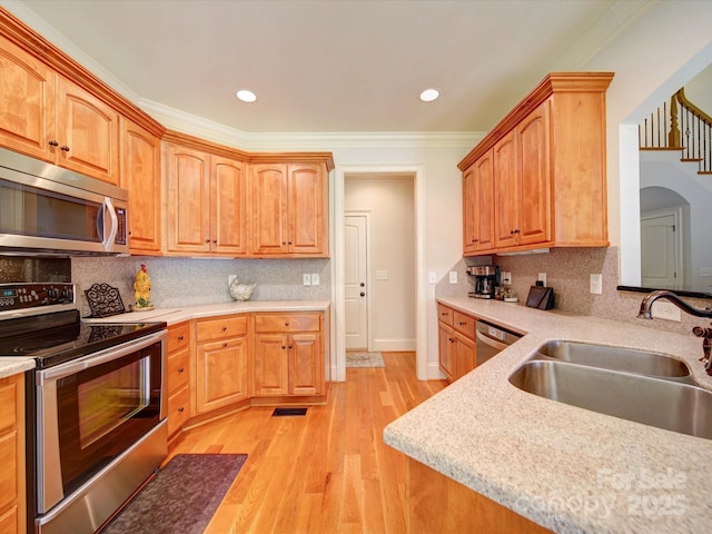 8101 Cane Pointe Ln, Waxhaw, NC 28173 - kitchen with stainless steel appliances, a sink, light countertops, light wood finished floors, and tasteful backsplash