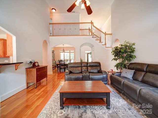 8101 Cane Pointe Ln, Waxhaw, NC 28173 - living area featuring arched walkways, a high ceiling, light wood-style flooring, ceiling fan, and baseboards