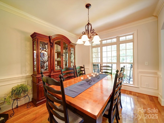8101 Cane Pointe Ln, Waxhaw, NC 28173 - dining area featuring a chandelier, healthy amount of natural light, ornamental molding, light wood-type flooring, and wainscoting