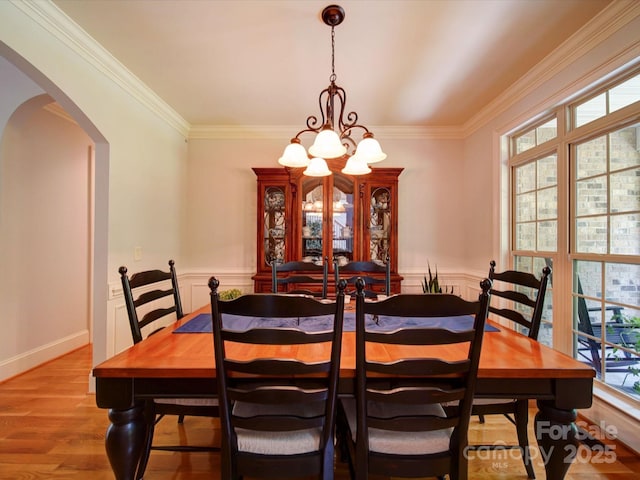 8101 Cane Pointe Ln, Waxhaw, NC 28173 - dining space featuring arched walkways, a chandelier, healthy amount of natural light, crown molding, and wood finished floors