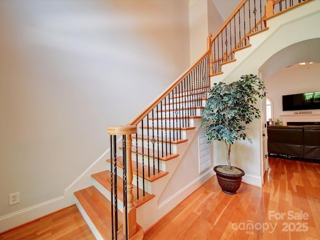 8101 Cane Pointe Ln, Waxhaw, NC 28173 - staircase featuring wood finished floors, arched walkways, and baseboards