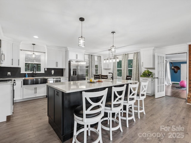 1238 Carl Allen Rd, Edgemoor, SC 29712 - kitchen with stainless steel appliances, white cabinets, light countertops, wood finished floors, and a kitchen island with sink