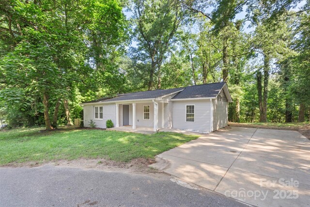 4410 Burgin St, Kannapolis, NC 28081 - ranch-style home with a porch, a front lawn, concrete driveway, and view of scattered trees