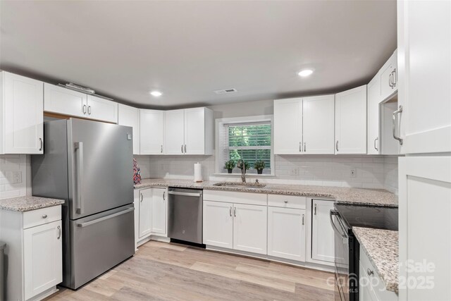 4410 Burgin St, Kannapolis, NC 28081 - kitchen with appliances with stainless steel finishes, white cabinets, decorative backsplash, and recessed lighting