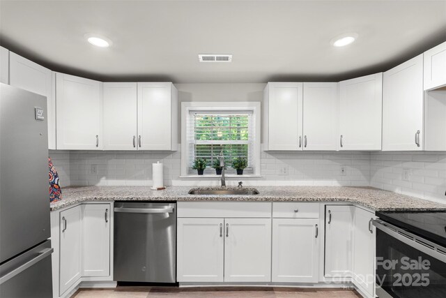 4410 Burgin St, Kannapolis, NC 28081 - kitchen featuring stainless steel appliances, white cabinetry, light stone countertops, backsplash, and recessed lighting