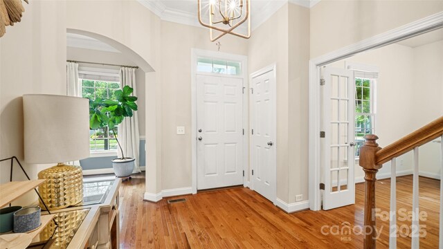 4115 Birkshire Hts, Fort Mill, SC 29708 - entrance foyer with arched walkways, light wood-style flooring, plenty of natural light, and crown molding