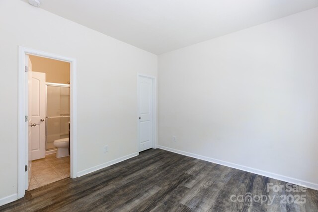 2180 Shady Pond Dr, Clover, SC 29710 - unfurnished bedroom with dark wood finished floors, baseboards, and connected bathroom
