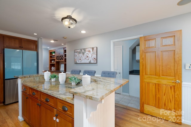 660 Ideal Way, Charlotte, NC 28203 - kitchen featuring fridge, a kitchen breakfast bar, light wood-style flooring, light stone countertops, and recessed lighting