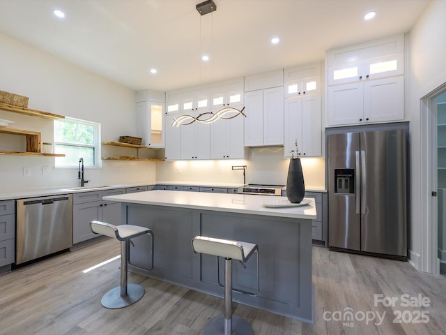 2004 Plain Field Dr, Bessemer City, NC 28016 - kitchen with appliances with stainless steel finishes, open shelves, a sink, light wood-style floors, and light countertops