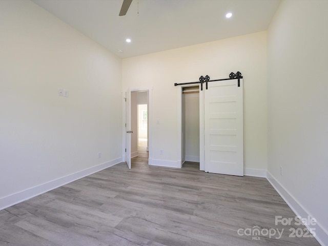 2004 Plain Field Dr, Bessemer City, NC 28016 - unfurnished bedroom featuring recessed lighting, baseboards, wood finished floors, a barn door, and ceiling fan