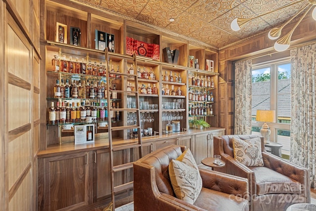 1172 Queens Rd, Charlotte, NC 28207 - sitting room featuring a bar, an ornate ceiling, wooden walls, and ornamental molding