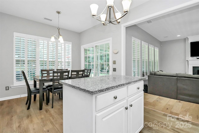 8722 Heron Glen Dr, Charlotte, NC 28269 - kitchen with a chandelier, light wood-style floors, a center island, open floor plan, and recessed lighting