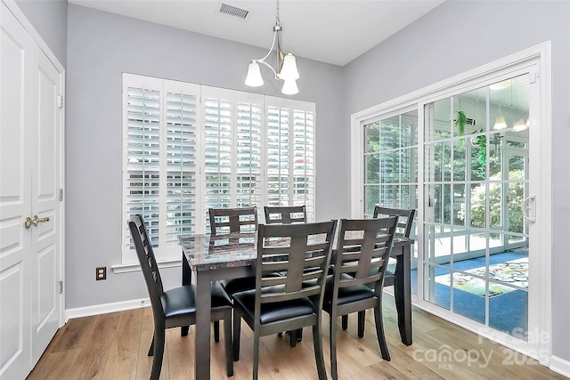 8722 Heron Glen Dr, Charlotte, NC 28269 - dining area featuring a chandelier, wood finished floors, plenty of natural light, and baseboards
