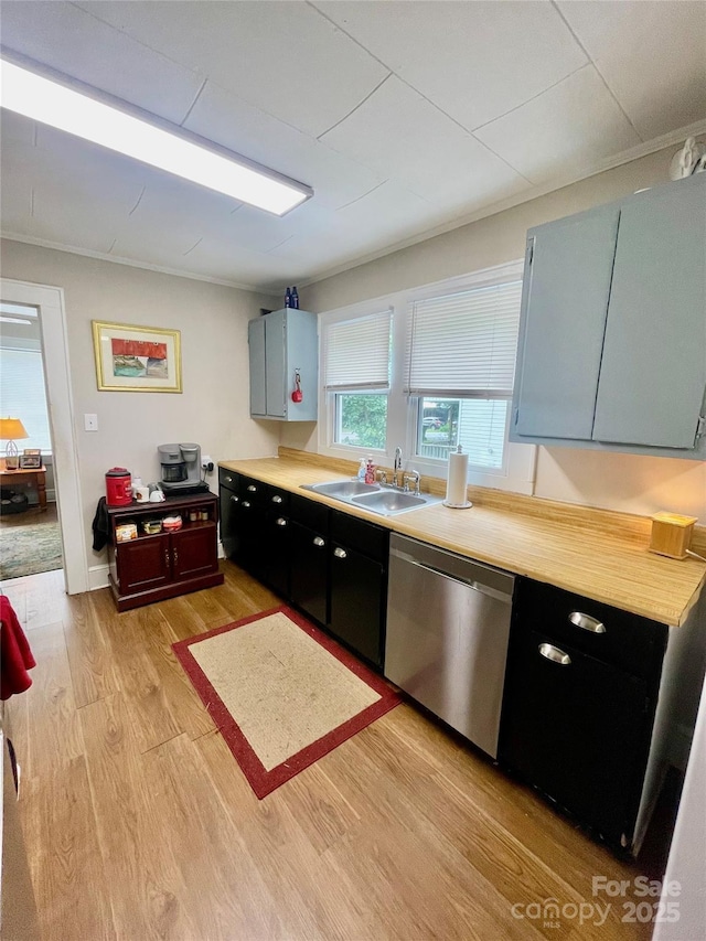 106 Peacock Ave, Lexington, NC 27292 - kitchen featuring dishwasher, a sink, light wood-type flooring, light countertops, and dark cabinetry
