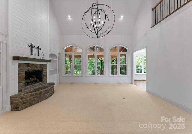 1108 Shinnecock Ln, Waxhaw, NC 28173 - unfurnished living room with high vaulted ceiling, a stone fireplace, a chandelier, carpet, and built in features