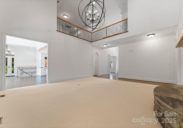 1108 Shinnecock Ln, Waxhaw, NC 28173 - living room with a chandelier, a towering ceiling, and wood finished floors