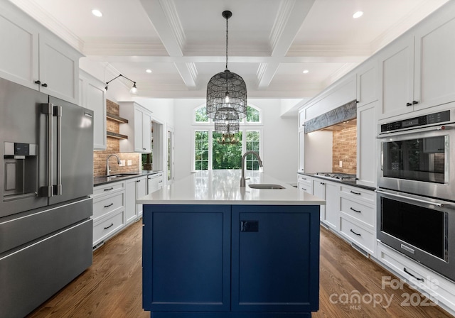 1108 Shinnecock Ln, Waxhaw, NC 28173 - kitchen featuring appliances with stainless steel finishes, ornamental molding, decorative backsplash, beam ceiling, and a kitchen island with sink